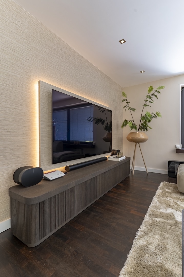 Grote ramen met houten vensterbank, decoratieve vazen en bloemen achter een comfortabele bank