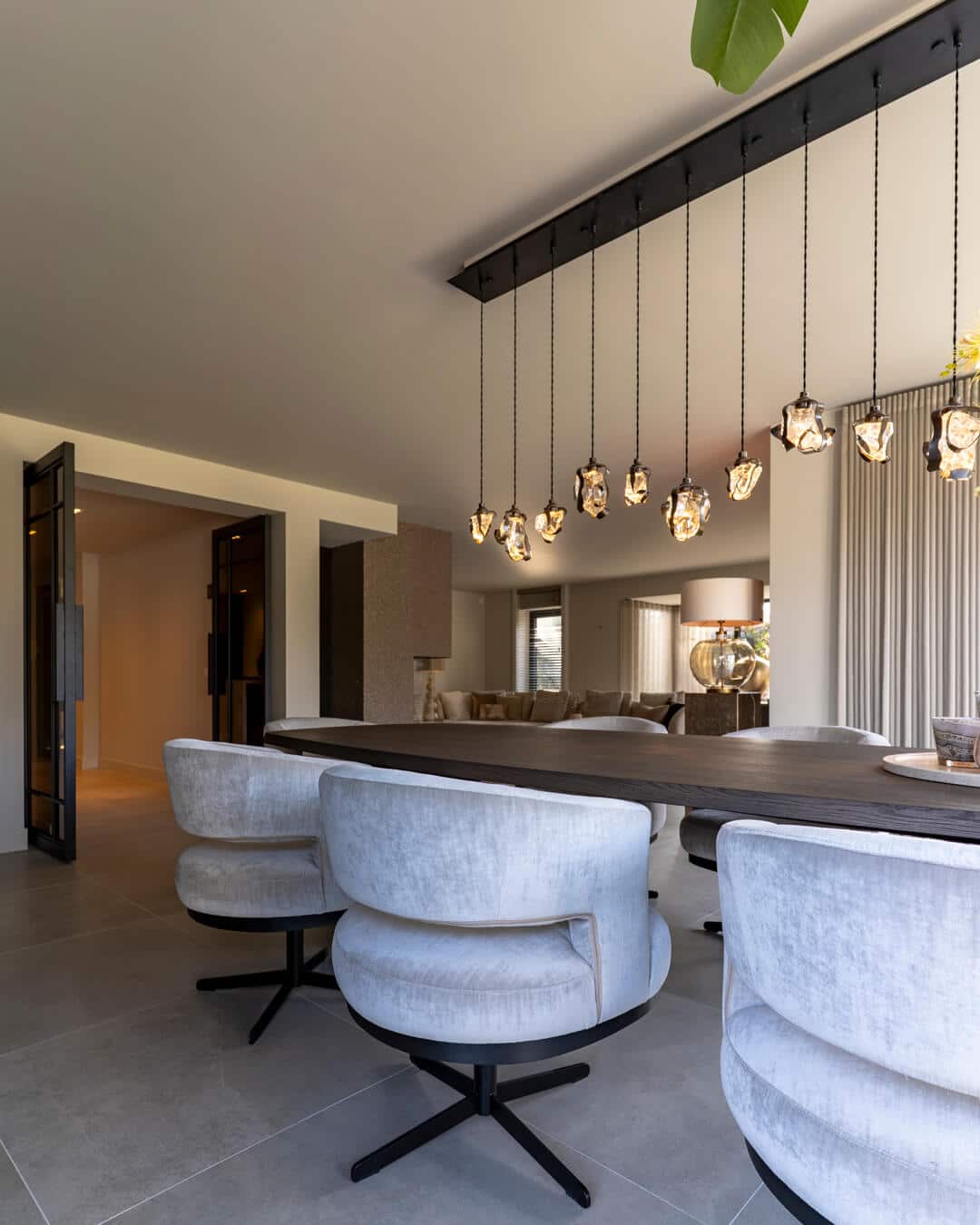 Luxe eetkamer met design hangverlichting en comfortabele beige eetkamerstoelen