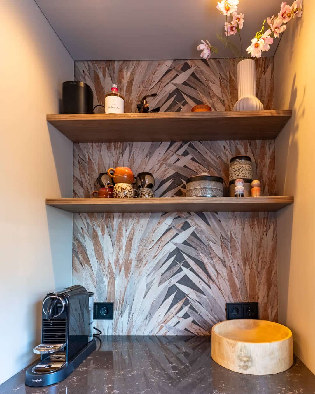 Koffienis met decoratief behang, houten wandplanken en keramieken accessoires