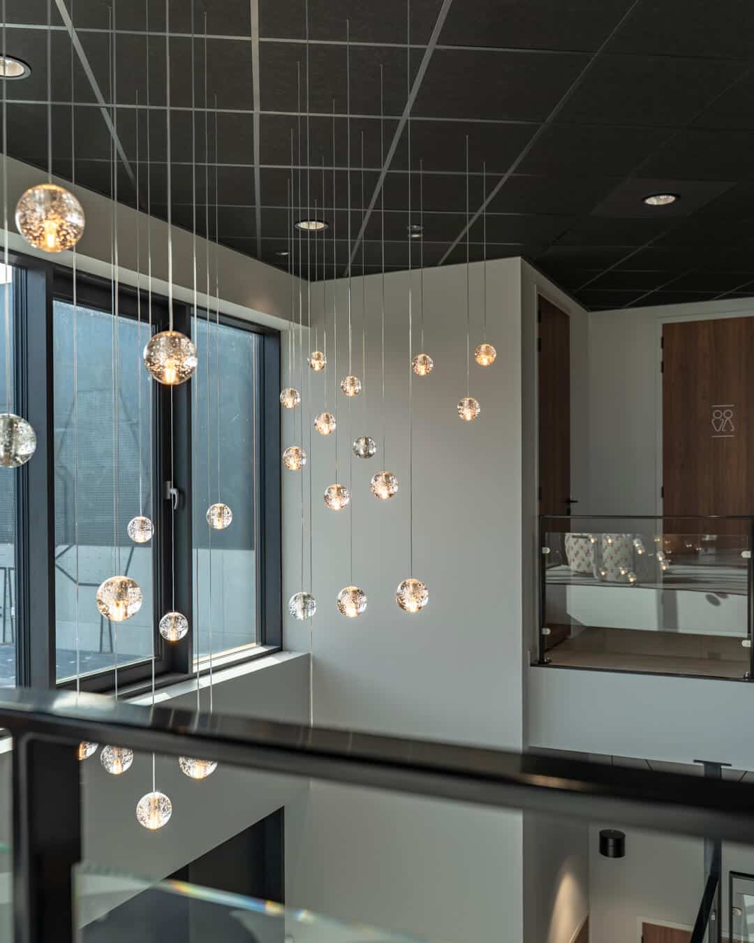 Vide met moderne hangverlichting en zwarte plafondafwerking in bedrijfspand