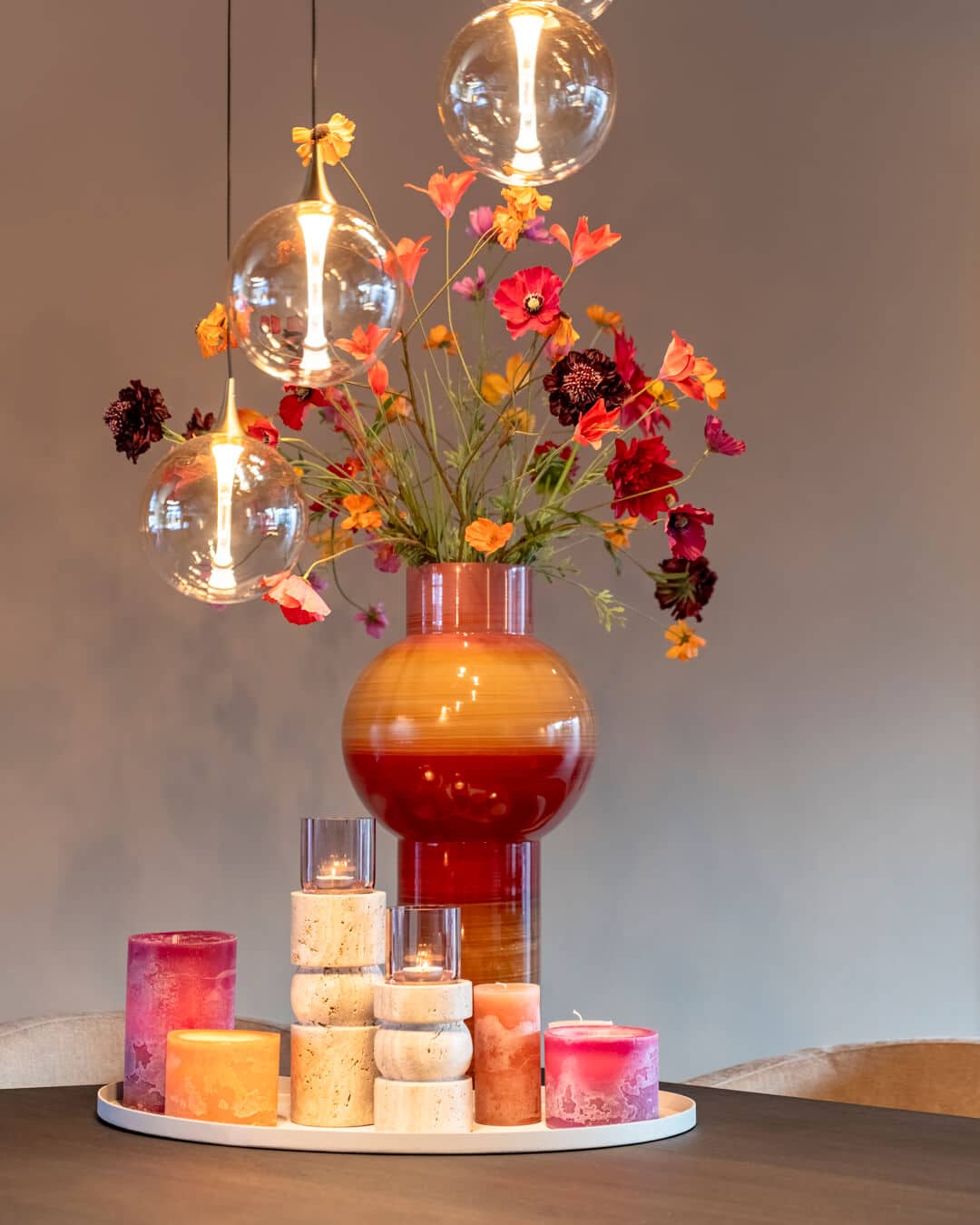 Kleurrijke bloemen en design hanglampen boven de eettafel