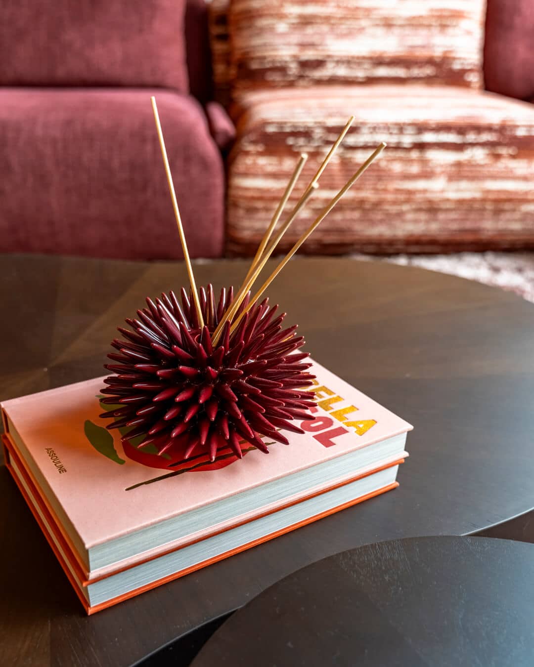 Decoratief woonaccessoire op design salontafel met kleurrijke bank op de achtergrond