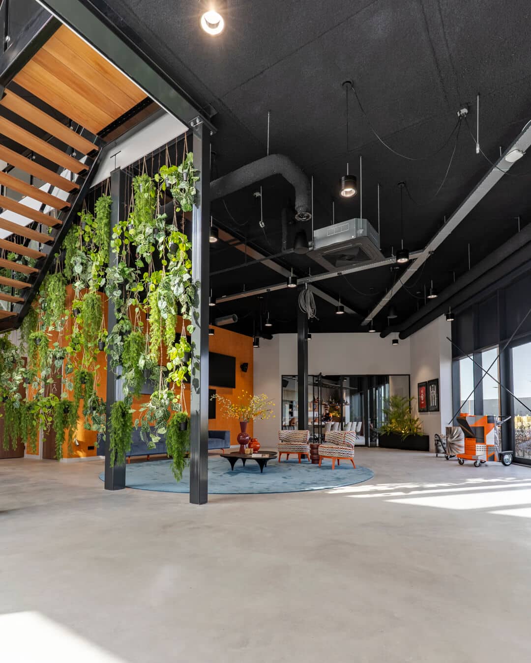 Moderne werkomgeving met groene plantenwand en kleurrijke lounge in bedrijfspand