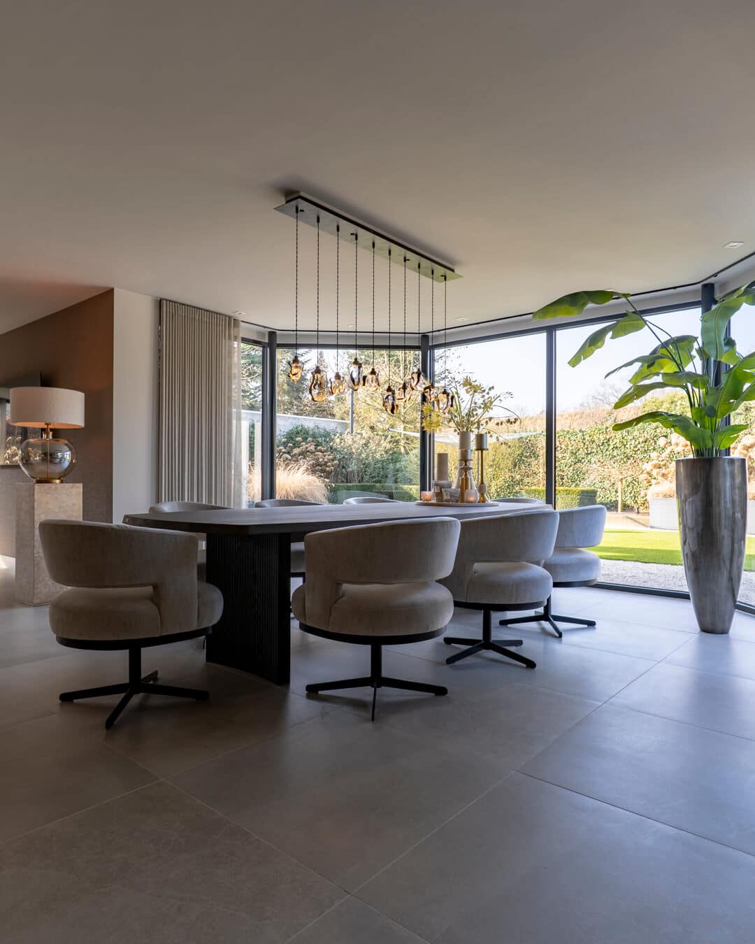 Ruime luxe eetkamer met maatwerk eettafel en zachte gestoffeerde stoelen