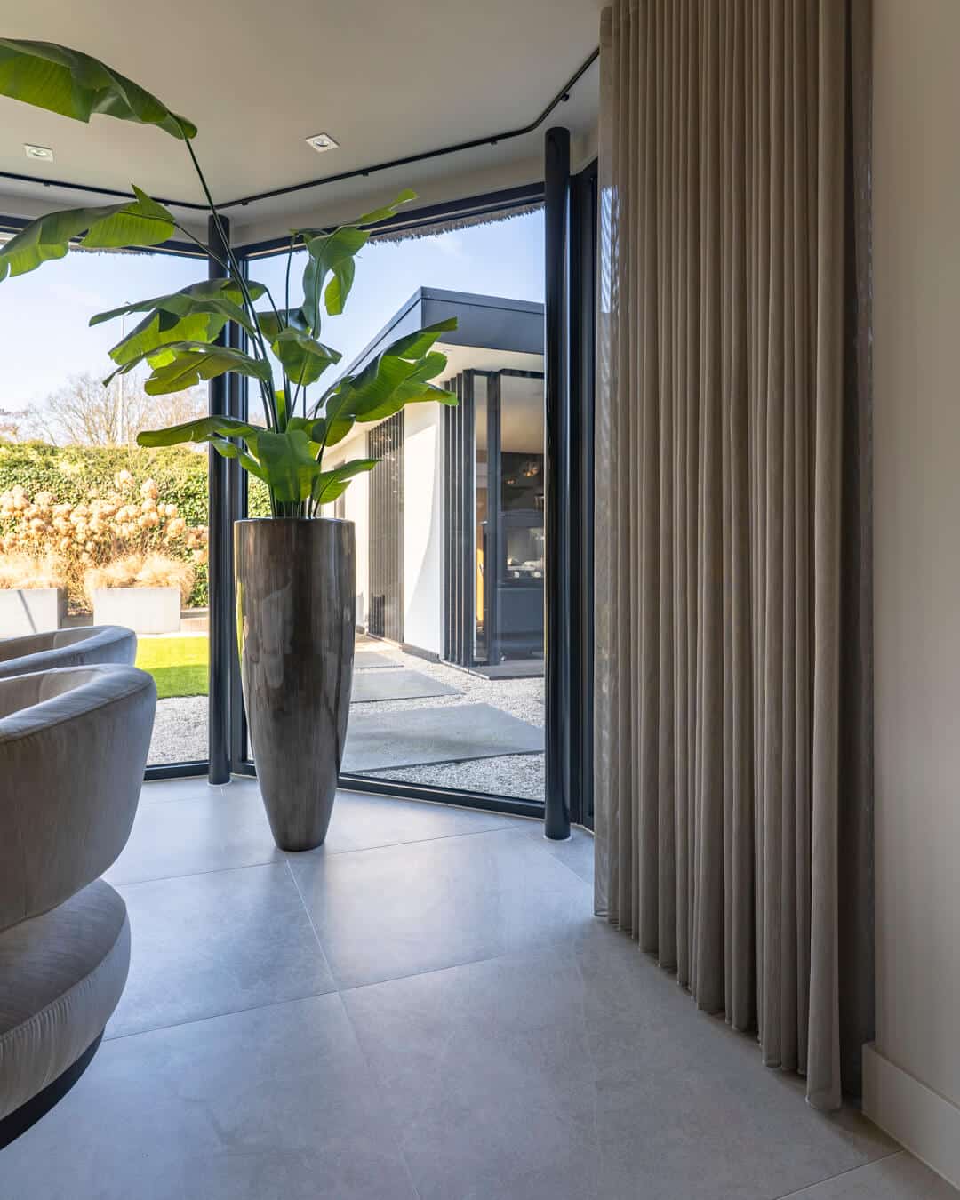 Hoge kamerplant in design plantenbak als groen accent in de eetkamer