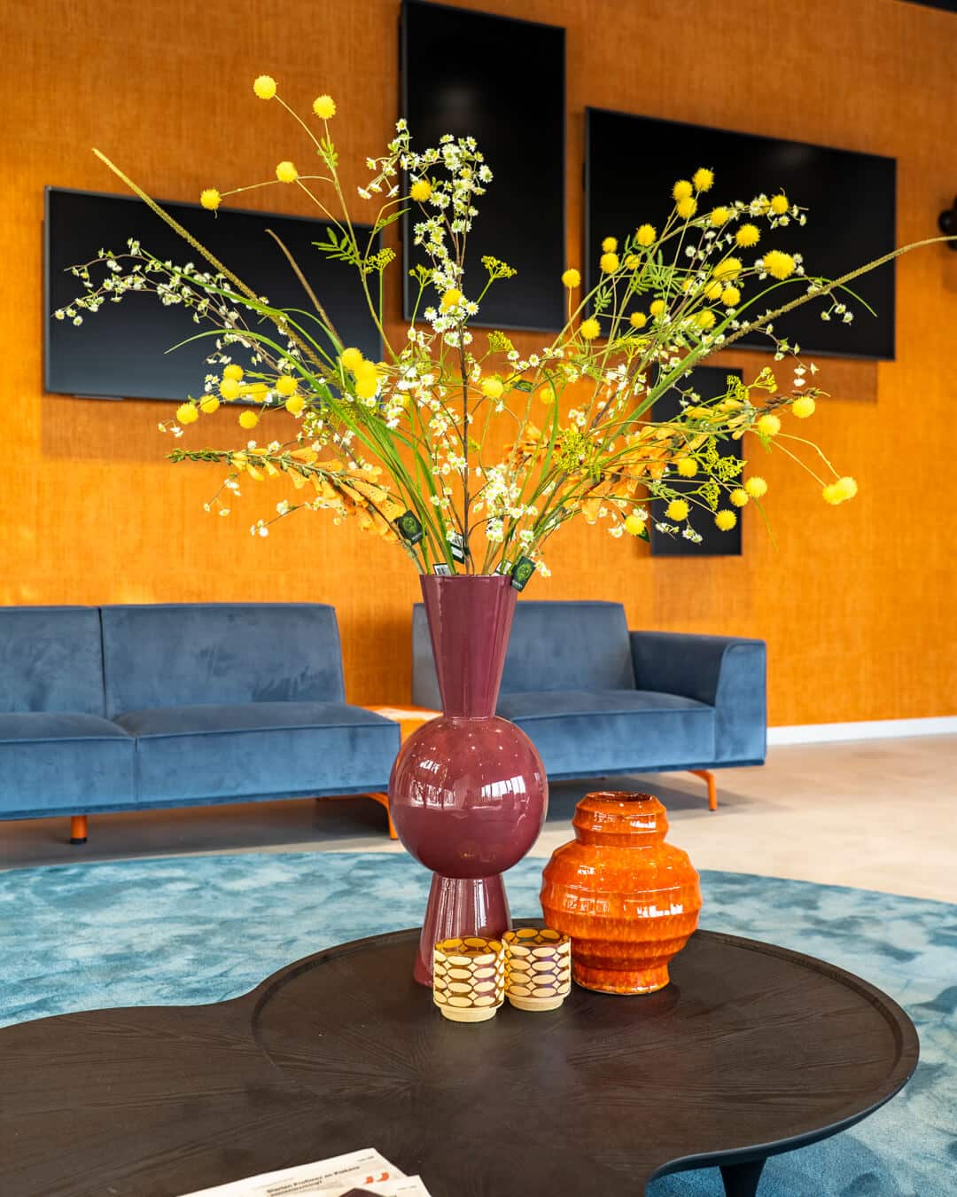 Kleurrijke bloemen en accessoires als blikvanger in moderne kantoorlounge