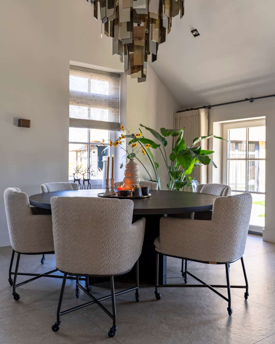 Luxe eethoek met ronde eettafel en comfortabele stoelen in een monumentale boerderij.