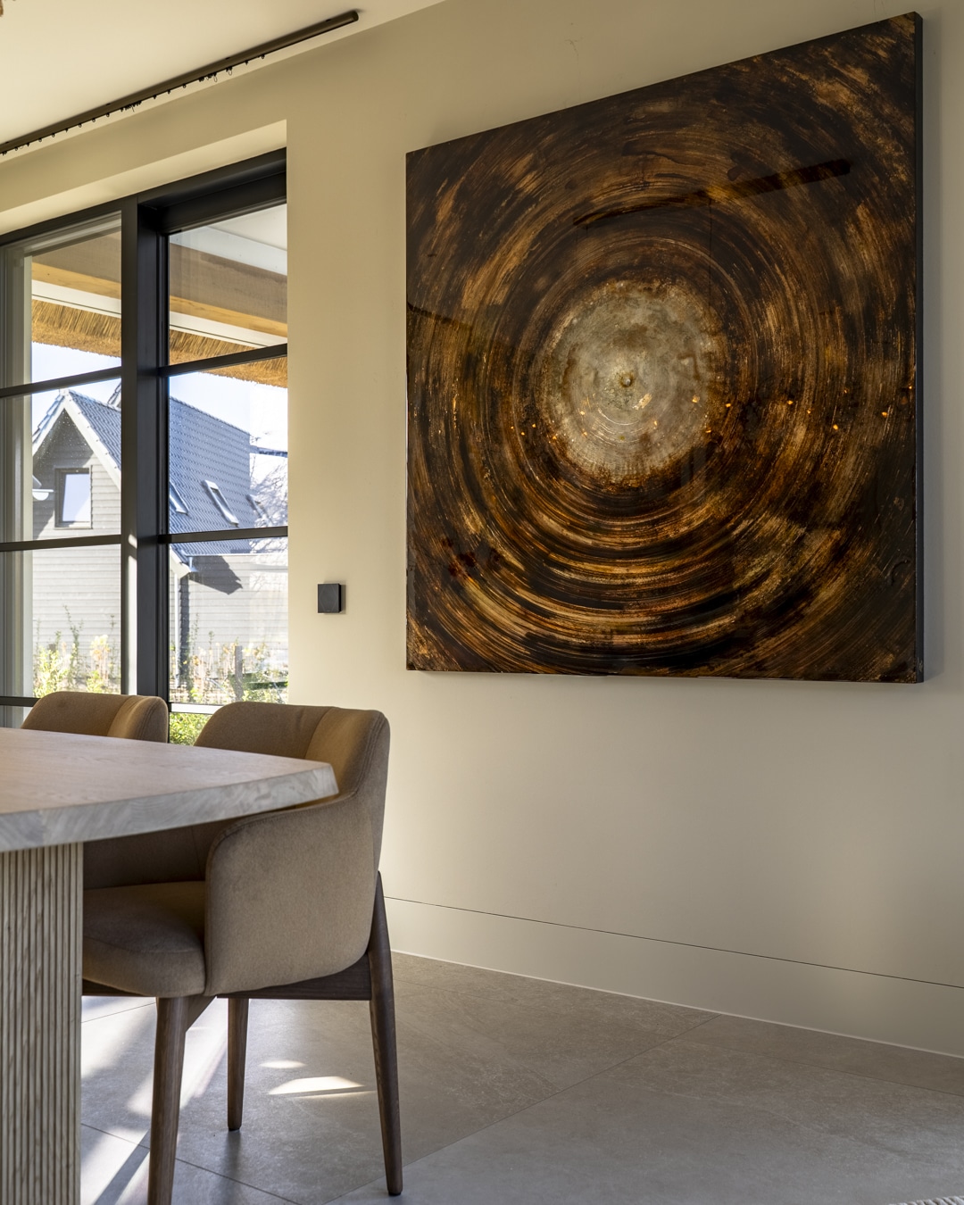 Complete eethoek in nieuwbouwvilla met designlamp, Cobra Art kunstwerk en warme materialen.