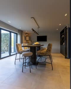 Eigen bar aan huis met royale bartafel, comfortabele stoelen en warme interieurstyling.