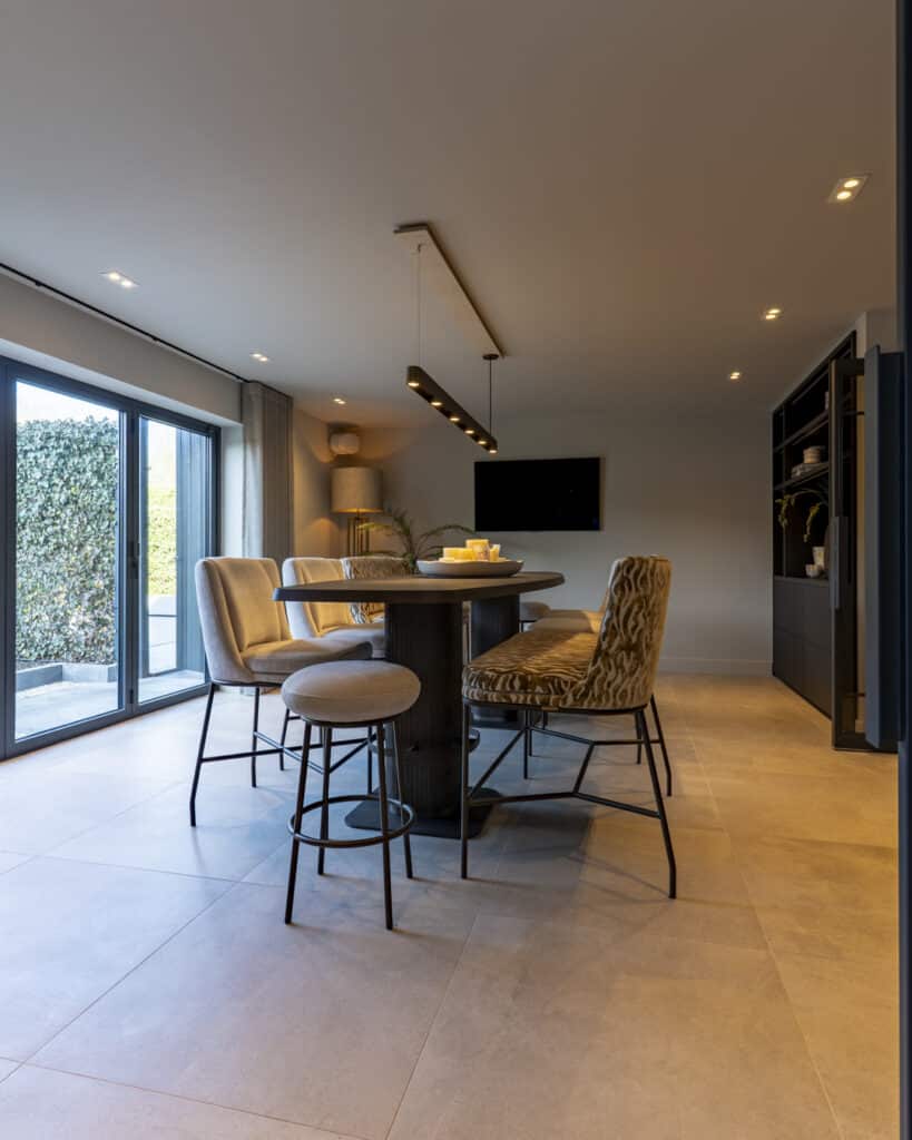 Eigen bar aan huis met royale bartafel, comfortabele stoelen en warme interieurstyling.