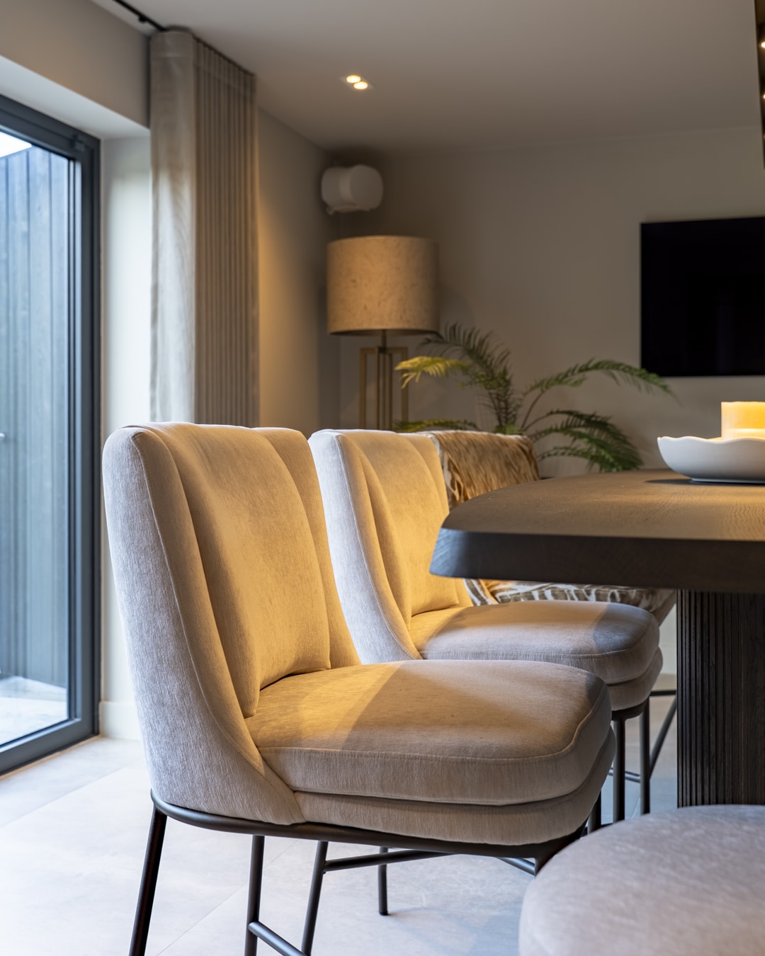 Luxe gestoffeerde stoel in zachte neutrale tint bij de bartafel.