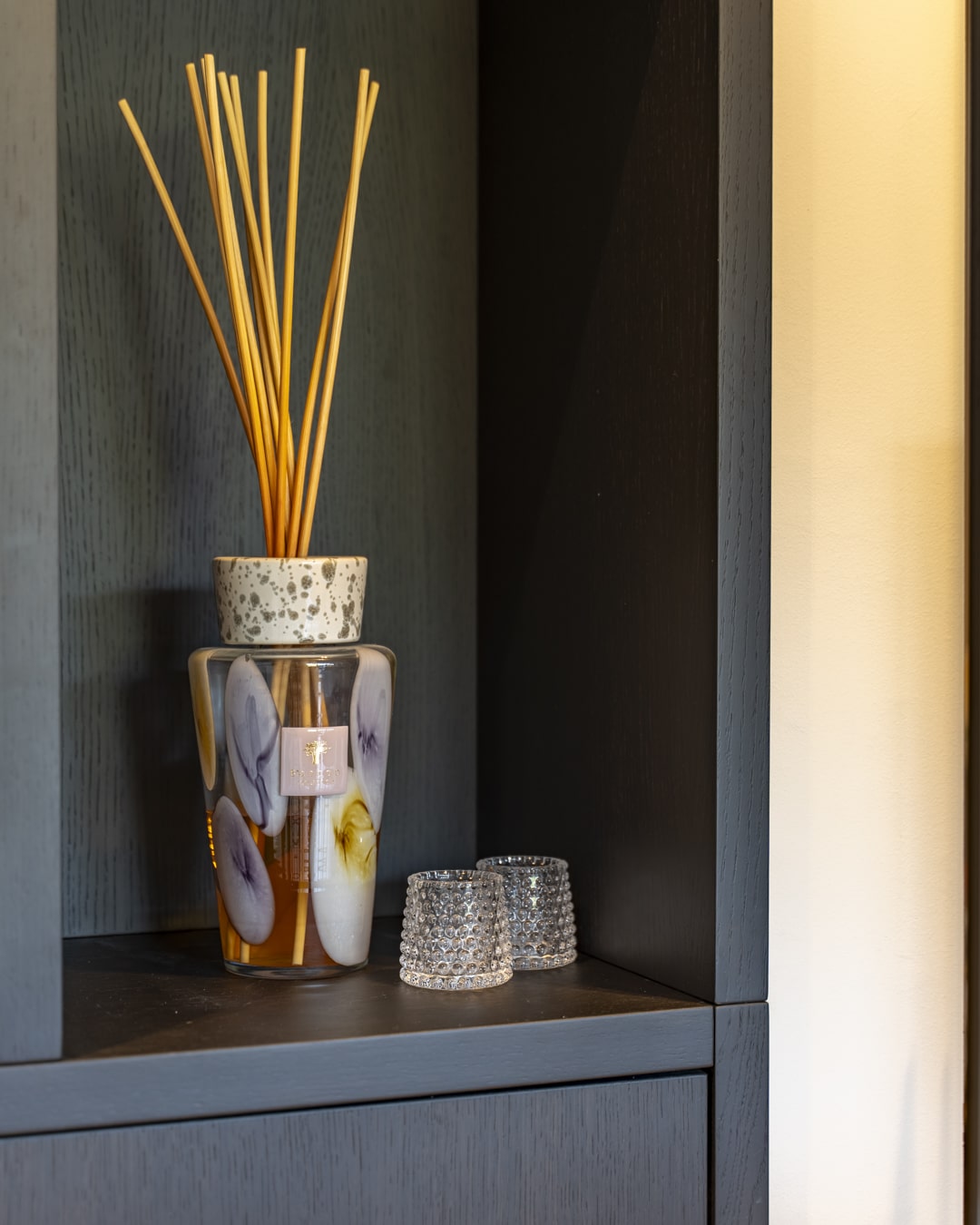 Luxe geurstokjes en decoratieve accessoires als detail in de maatwerkkast.
