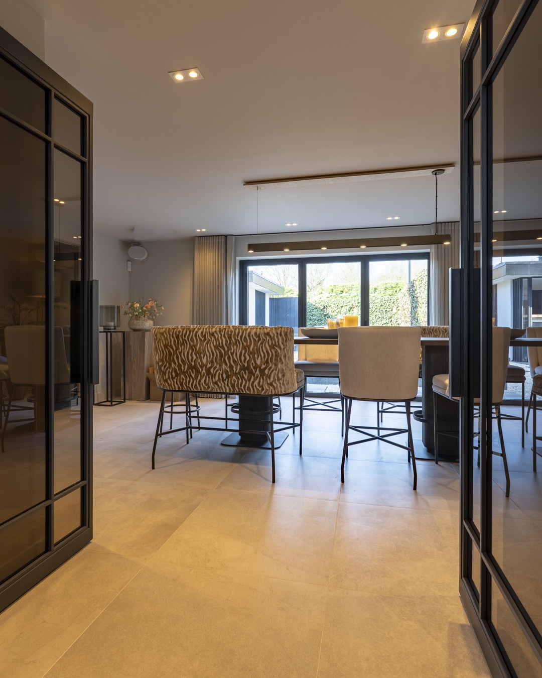 Moderne thuisbar bij de woonkeuken met grote bartafel en verschillende comfortabele zitplaatsen.
