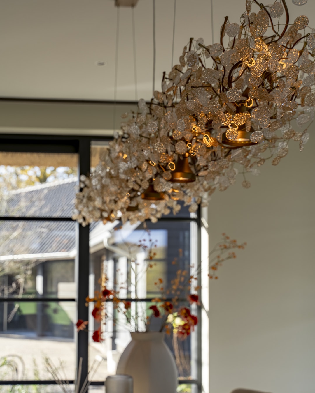 Organisch gevormde designlamp als luxe detail in de eethoek van een nieuwbouwvilla.